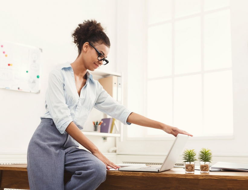 business-woman-opening-laptop-at-office-PU4ZAGW_rtl-min